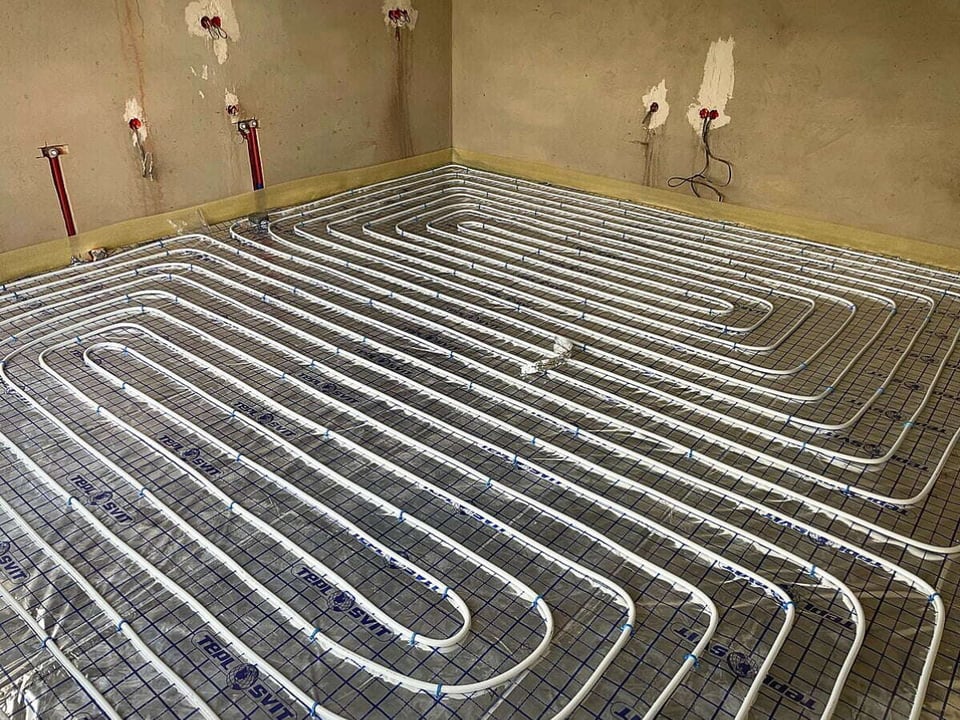 Hydronic heated floor covered by thin sheets during a construction