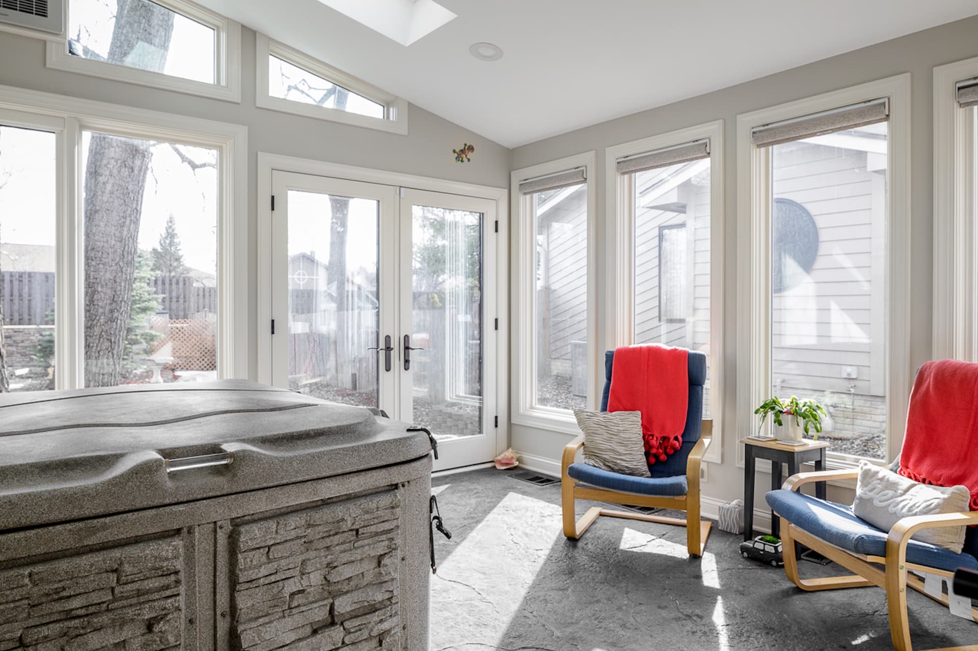 A concrete sunroom with steel and glass floor-to-ceiling windows