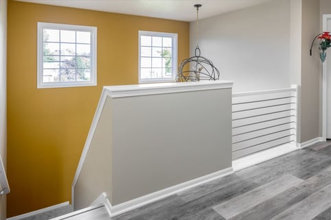Full-Home Remodel Yellow Accent Wall with Industrial Accent Lighting and Conduit Railing