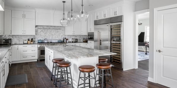 Timeless and Classy Twist on an All-White Kitchen with Oversized Fridge and Freezer, Wine Cooler, and Beautiful Tile Backsplash by Compelling Homes
