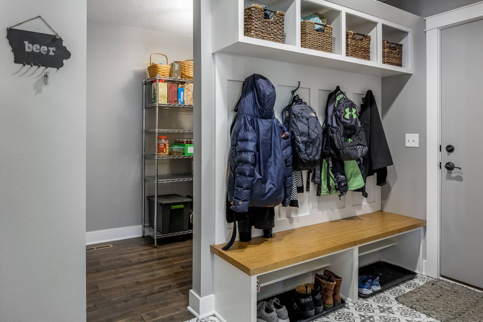 A mudroom in a home with a tucked-away storage area that doubles as a panty