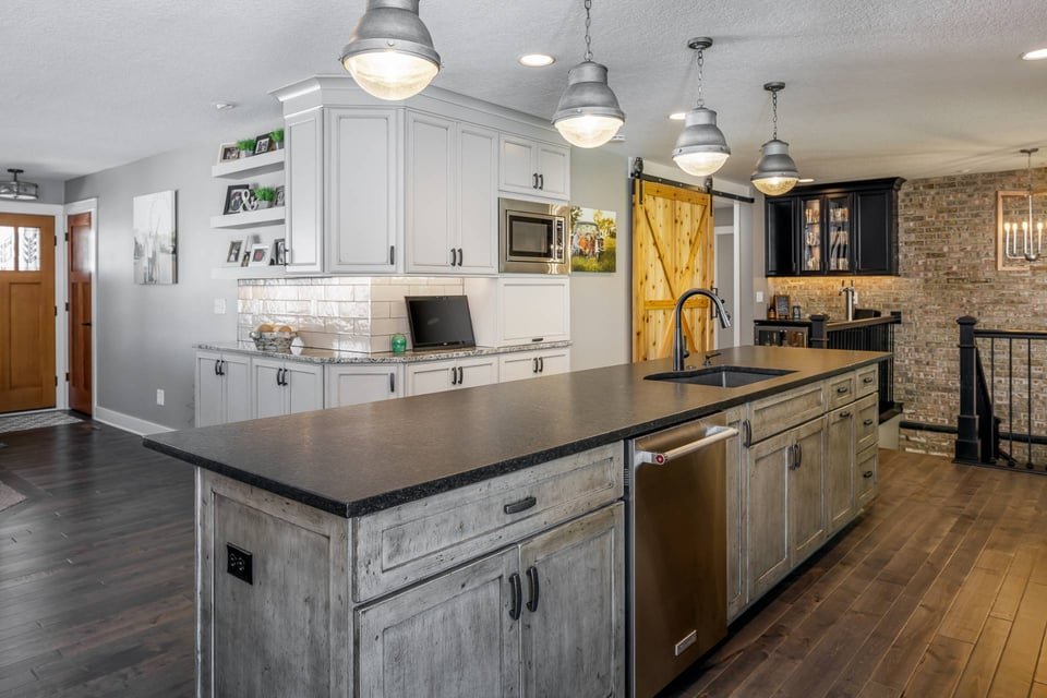 Soapstone countertop with pendant light fixtures overhead, in a kitchen
