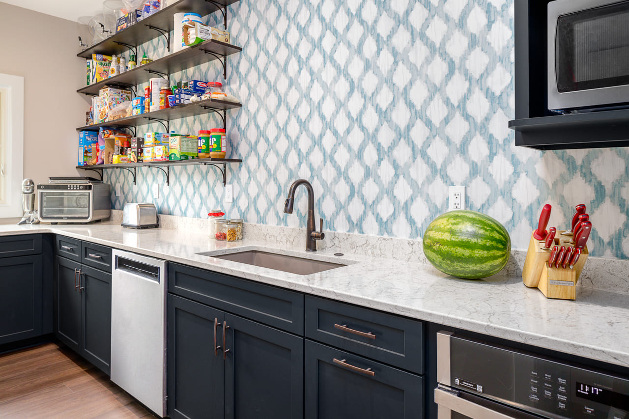 Side Kitchen with Blue Wallpaper and Navy Blue Cabinets | Compelling Homes