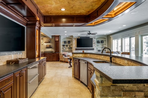 Custom Bar Overlooking Living Room and Custom Buffet Area for Entertaining in Large Walk Out Basement Remodel with Natural Light | Compelling Homes Des Moines, IA