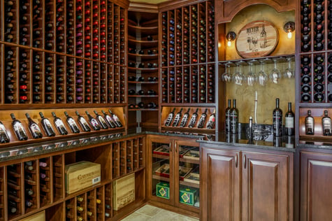 In-Home Wine Cellar with Custom Shelving Units and Tasting Area in Walk Out Basement | Compelling Homes Des Moines, IA