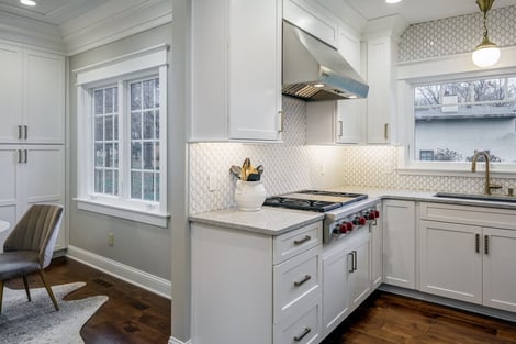 Kitchen Looking Into Sitting Area with Rose Gold Kitchen Hardware and Professional Grade Appliances Against Tile Backsplash | Compelling Homes Design-Build Experts in Des Moines, IA