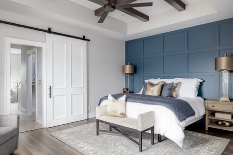 Primary Bedroom with Ceiling Rafters and Cool Blue Accent Wall | Compelling Homes Remodel + Design