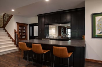Leather bar stools in a basement bar remodeled by Compelling Homes