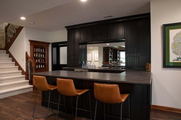 Leather bar stools in a basement bar remodeled by Compelling Homes
