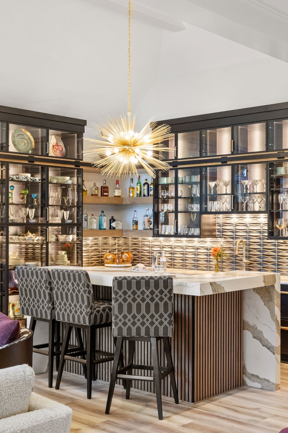 Luxury wine bar in a home with custom fabrics used on the bar stools and a marble countertop that doubles as sink