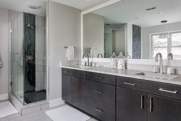 Modern bathroom with espresso double vanity, marble counters, marble shower, and contemporary fixtures