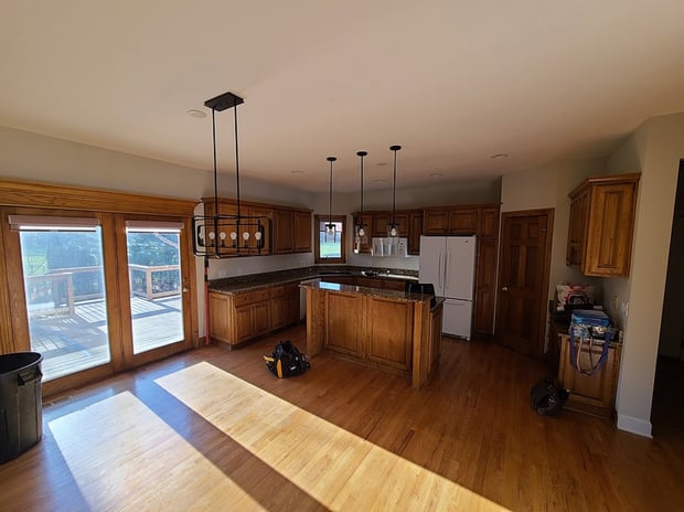 Outdated kitchen with golden oak cabinets, dark granite counters, and original hardwood floors before remodel