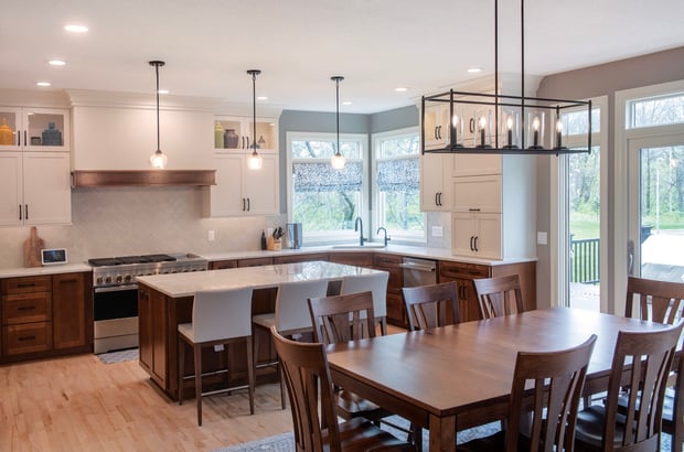Transitional kitchen with two-tone wood and white cabinets, gray tile backsplash, and adjacent dining area