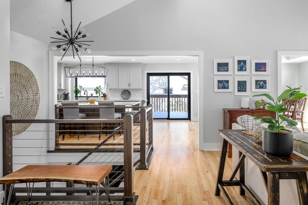 Open-concept living and kitchen area with sputnik chandelier, modern cable railings, and updated finishes