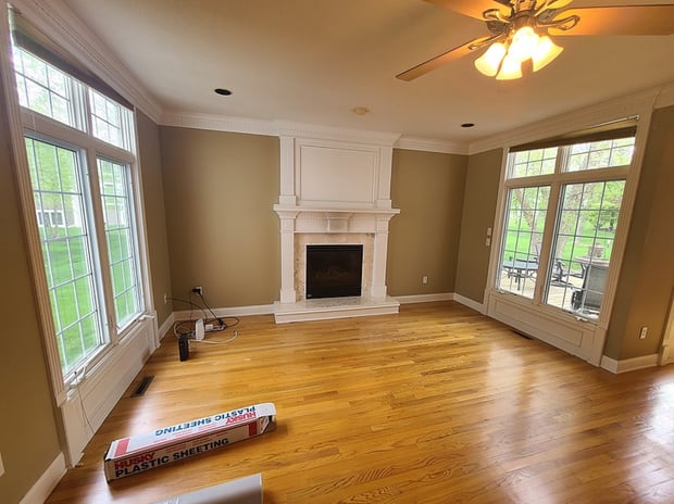 Traditional living room with painted fireplace mantel, brass fireplace insert, and dated finishes before remodel