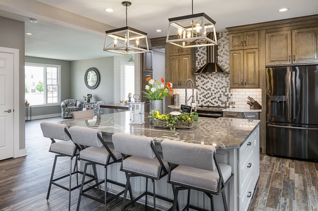 Modern open-concept main floor with stained wood cabinets, geometric pendants, hex penny-tile backsplash, and gray island