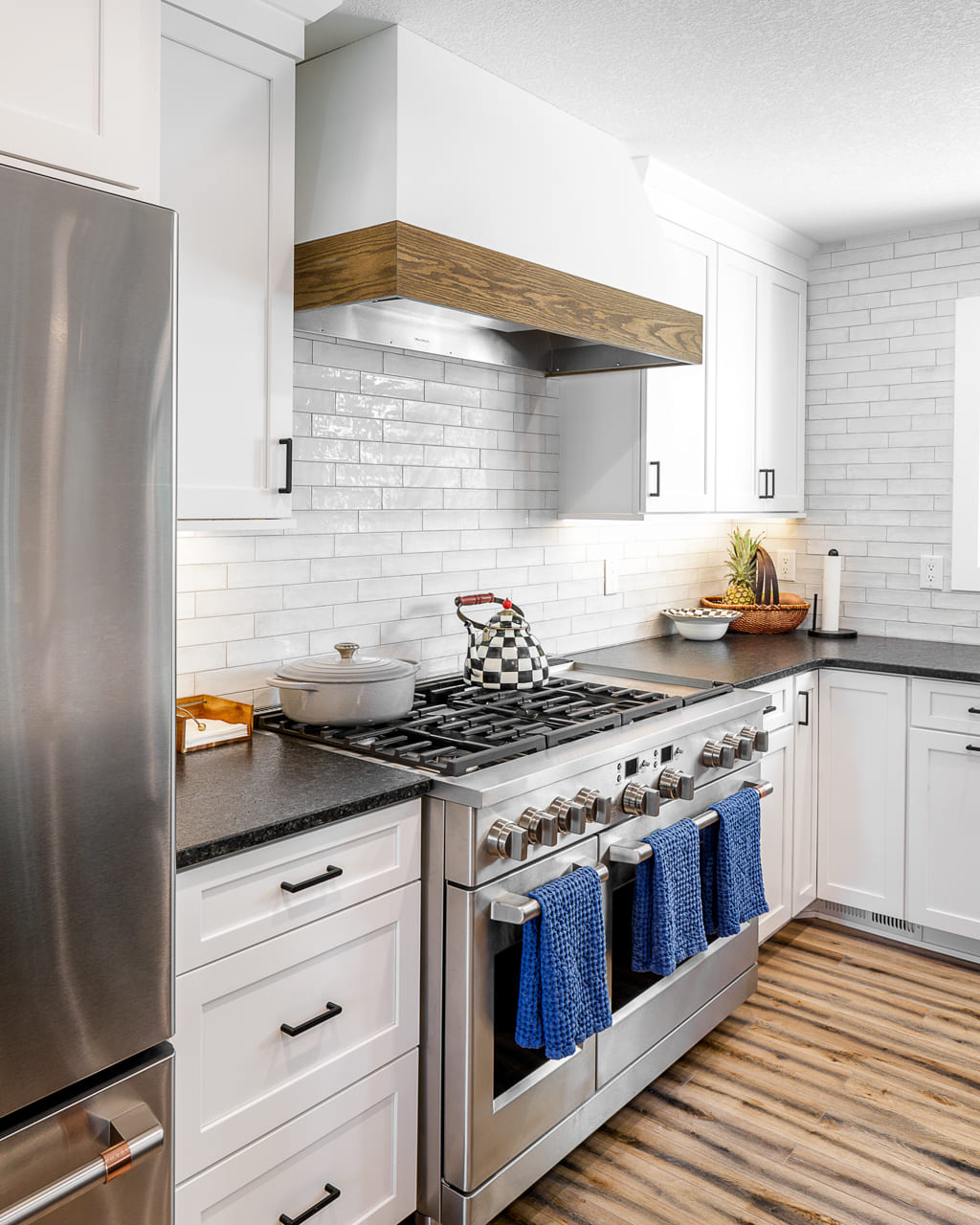 Chef Area with Wood-Trimmed Exhaust and Glass Subway Tile | Compelling Homes