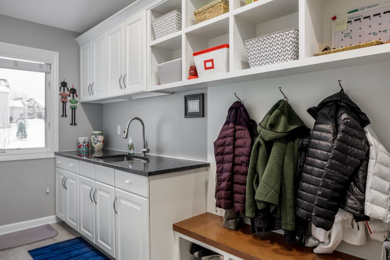 Laundry room featuring sink and workstation below custom cabinets