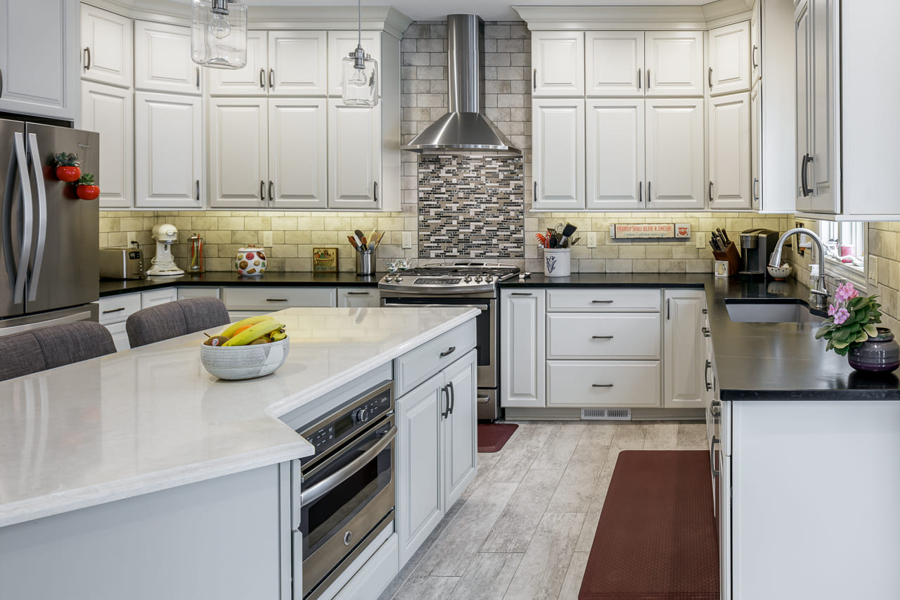 White cabinet kitchen with large island featuring built-in appliances