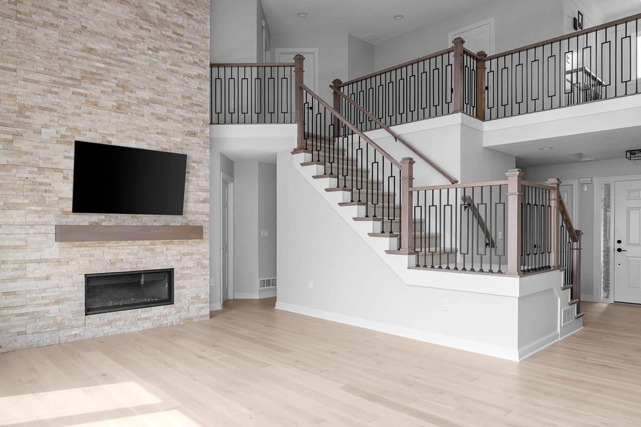 Large Living Room Remodel with Stone Fireplace and Staircase | Compelling Homes